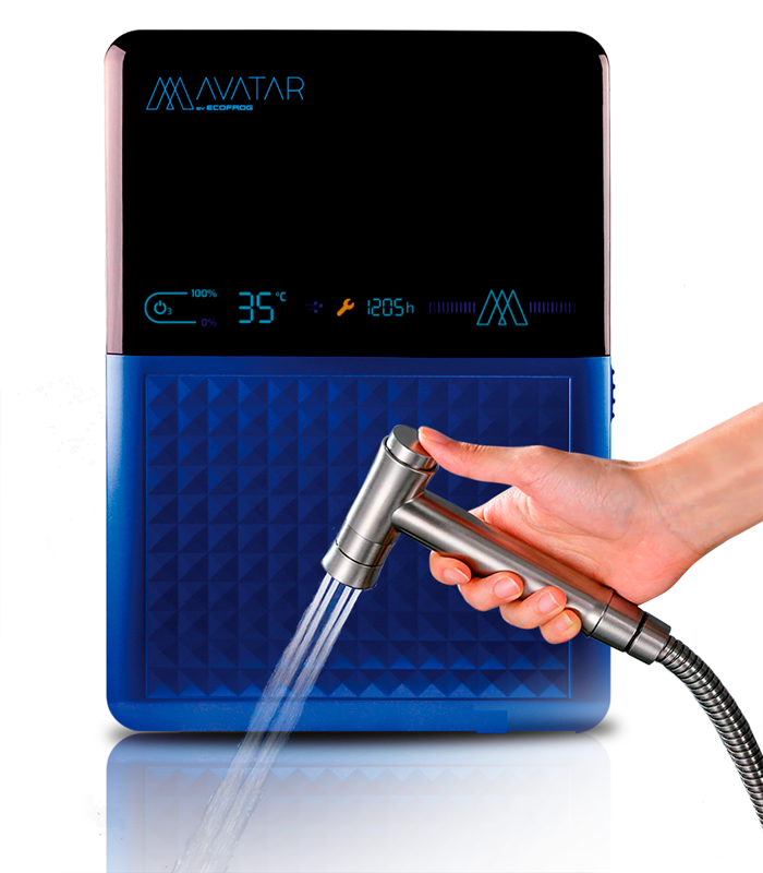 Máquina AVATAR da ECOFROG, metade azul com um motivo em relevo de pequenas pirâmides e metade preta. Esta parte escura corresponde a um ecrã LED que está aceso, onde se podem ver vários indicadores e ações ativas, com o seu reflexo projetado na base da imagem e uma torneira segurada por uma mão feminina a expelir água ozonizada.